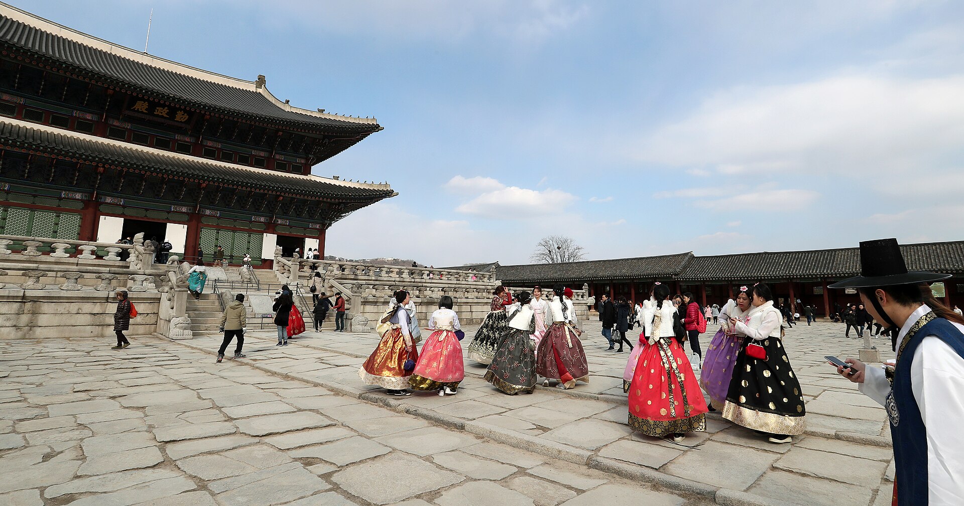 Visitors wearing colourful hanbok in the courtyard of a Seoul palace