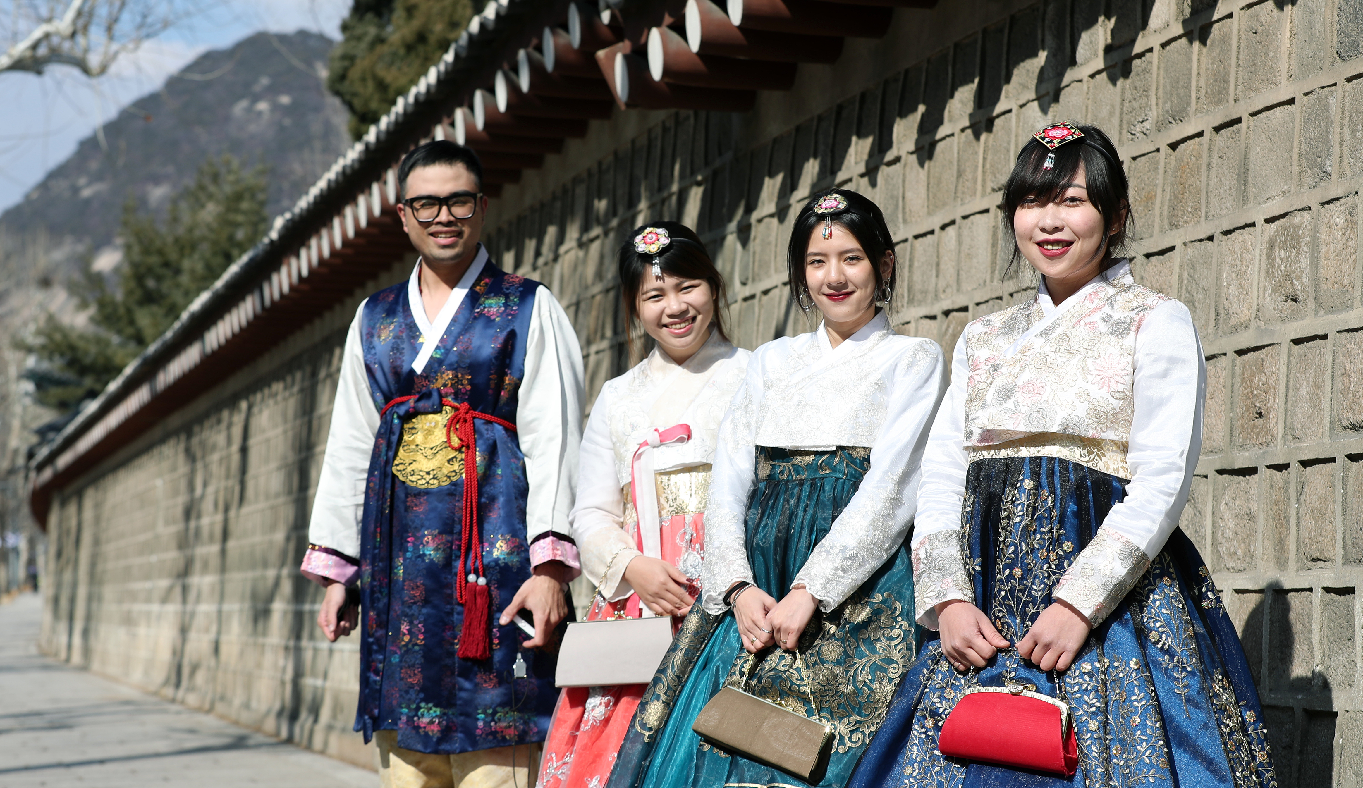 Visitors wearing hanbok walking through Gyeongbokgung Palace in Seoul
